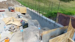 Concrete wall with rebar sticking out, various tools laying around