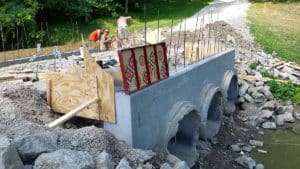 Laying concrete for a bridge over pipes and water pool