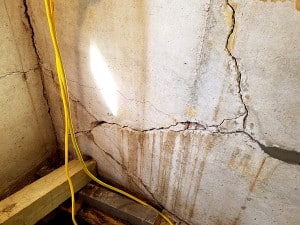 Large cracks snaking across concrete wall