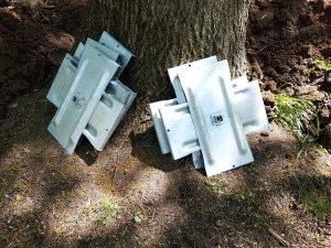Metal plates leaning against a tree