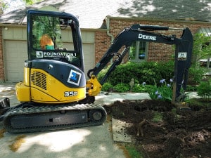Foundation 1 backhoe digs hole in front yard