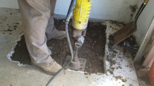 Man jackhammering concrete floor