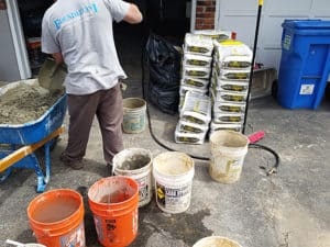 Man mixing concrete with shovel
