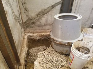 Sump pump installation hole filled with rocks