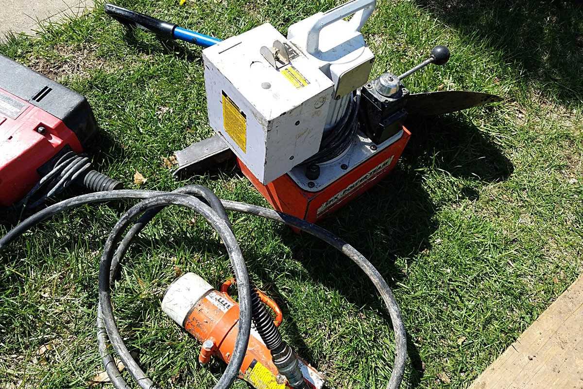 Sump pump equipment and hoses set up on grass at a commercial job site